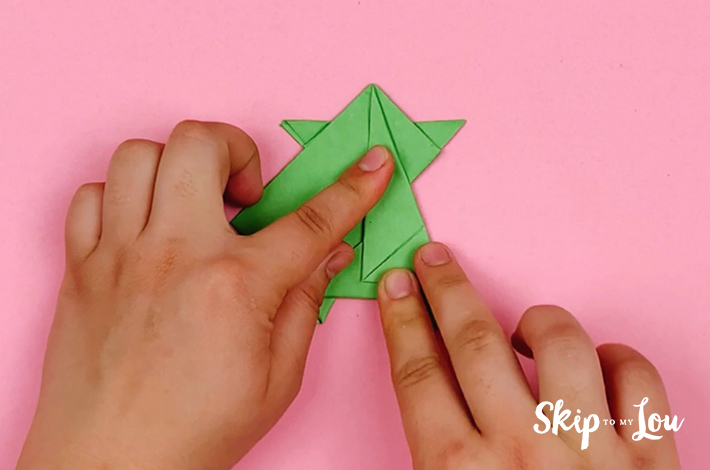 Two hands folding the right corner over to the center. 
