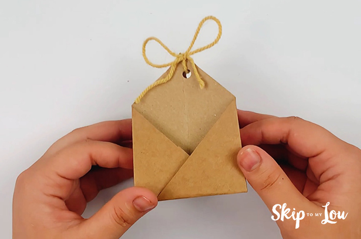 A string is placed through the two holes to secure the origami party favor. 