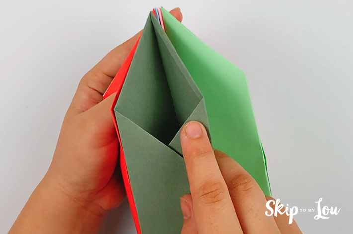 Two hands adding each section of the paper pen holder together.