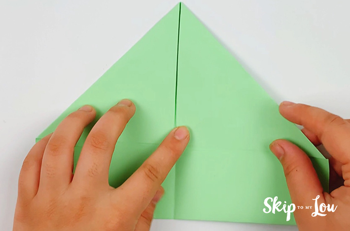 Two hands unfolding the paper.
