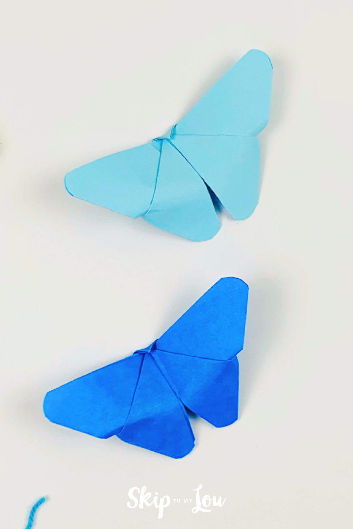 Two folded origami butterflies made with step-by-step instructions from Skip to My Lou.