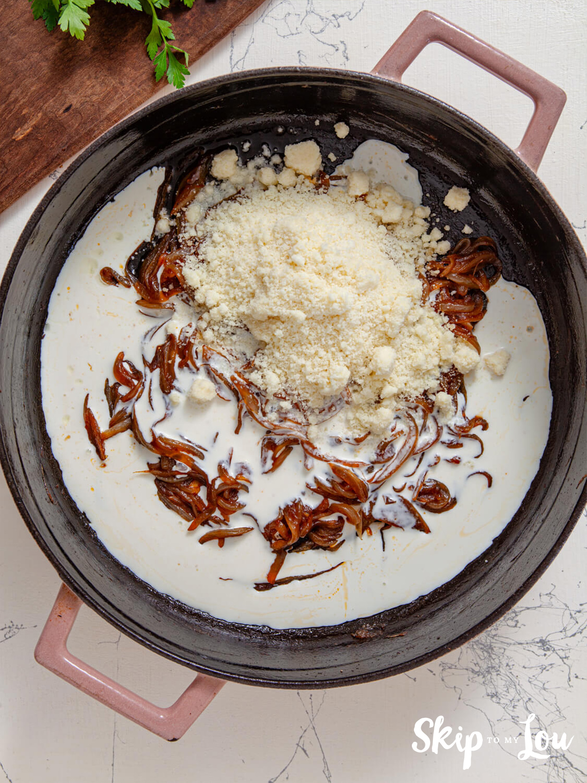 A skillet with caramelized onions with cream, parmesan and lemon added.