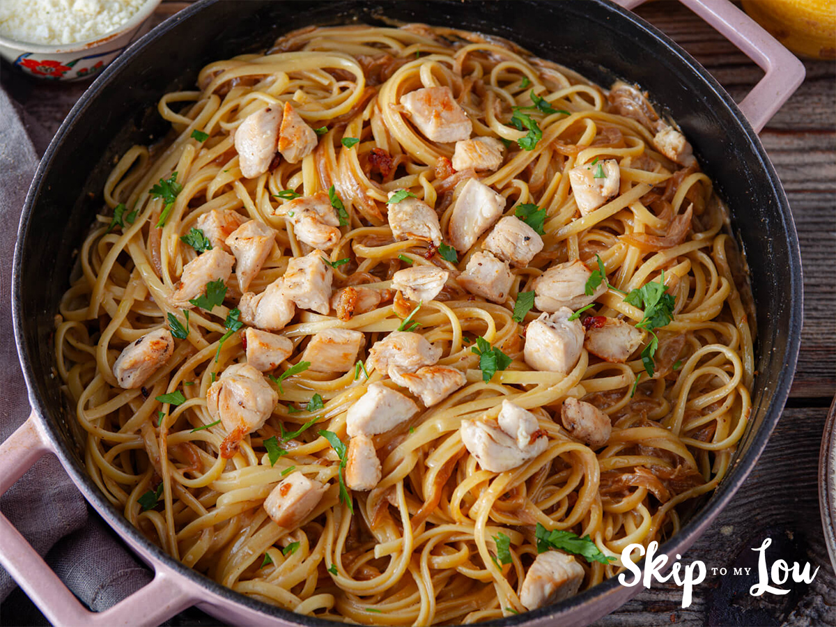 A caramelized onion and chicken linguine ready to be served from a pan and made with a recipe from Skip to my Lou.
