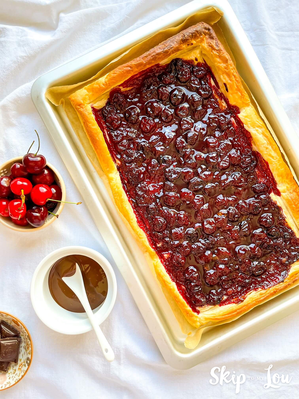 Puff pastry and cherry tart waiting to be drizzled with chocolate. 
