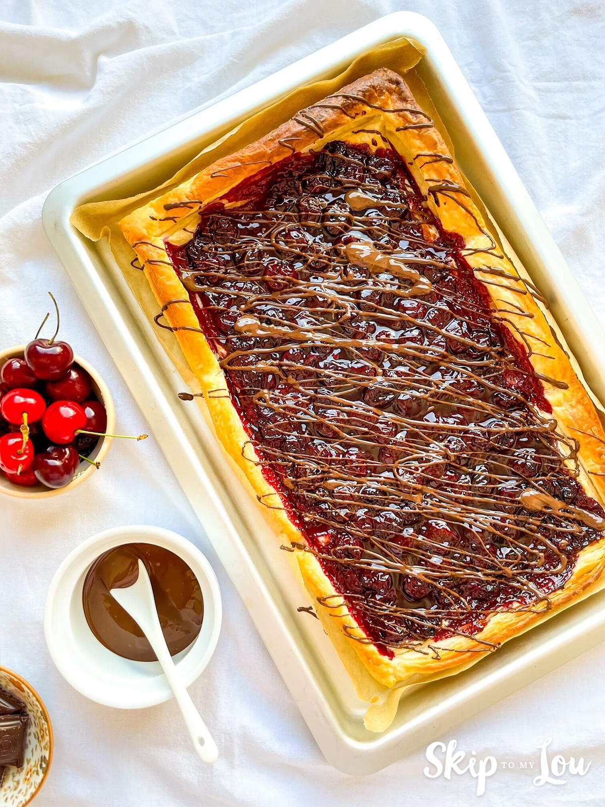 Cherry and puff pastry tart drizzled with chocolate. 
