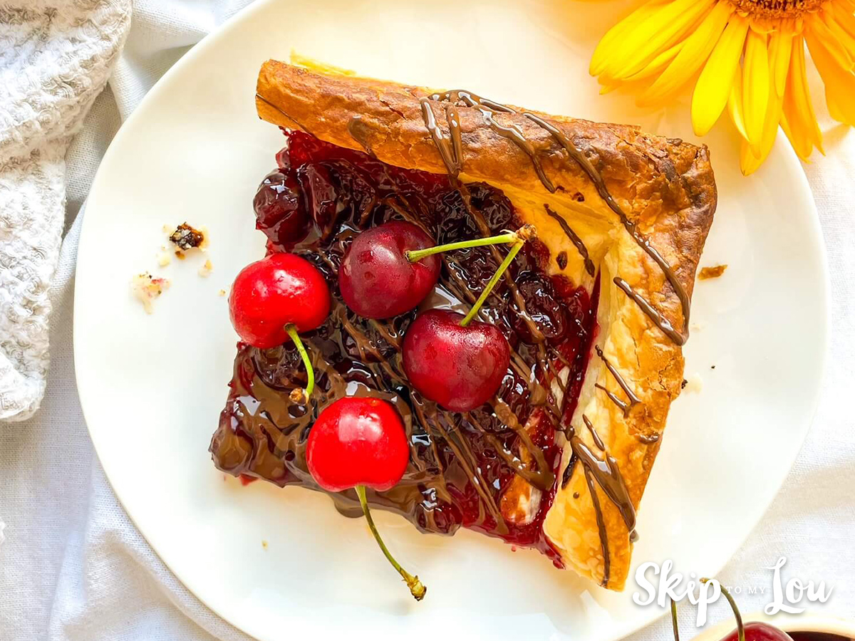 Cherry and chocolate tart on a plate made from a Skip to My Lou recipe. 