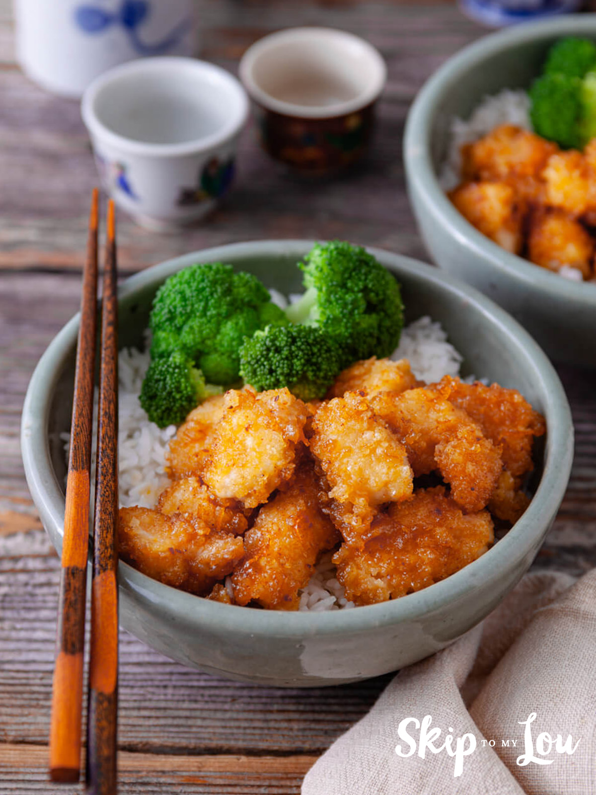 Easy baked organge chicken served with rice and broccoli in a bowl.