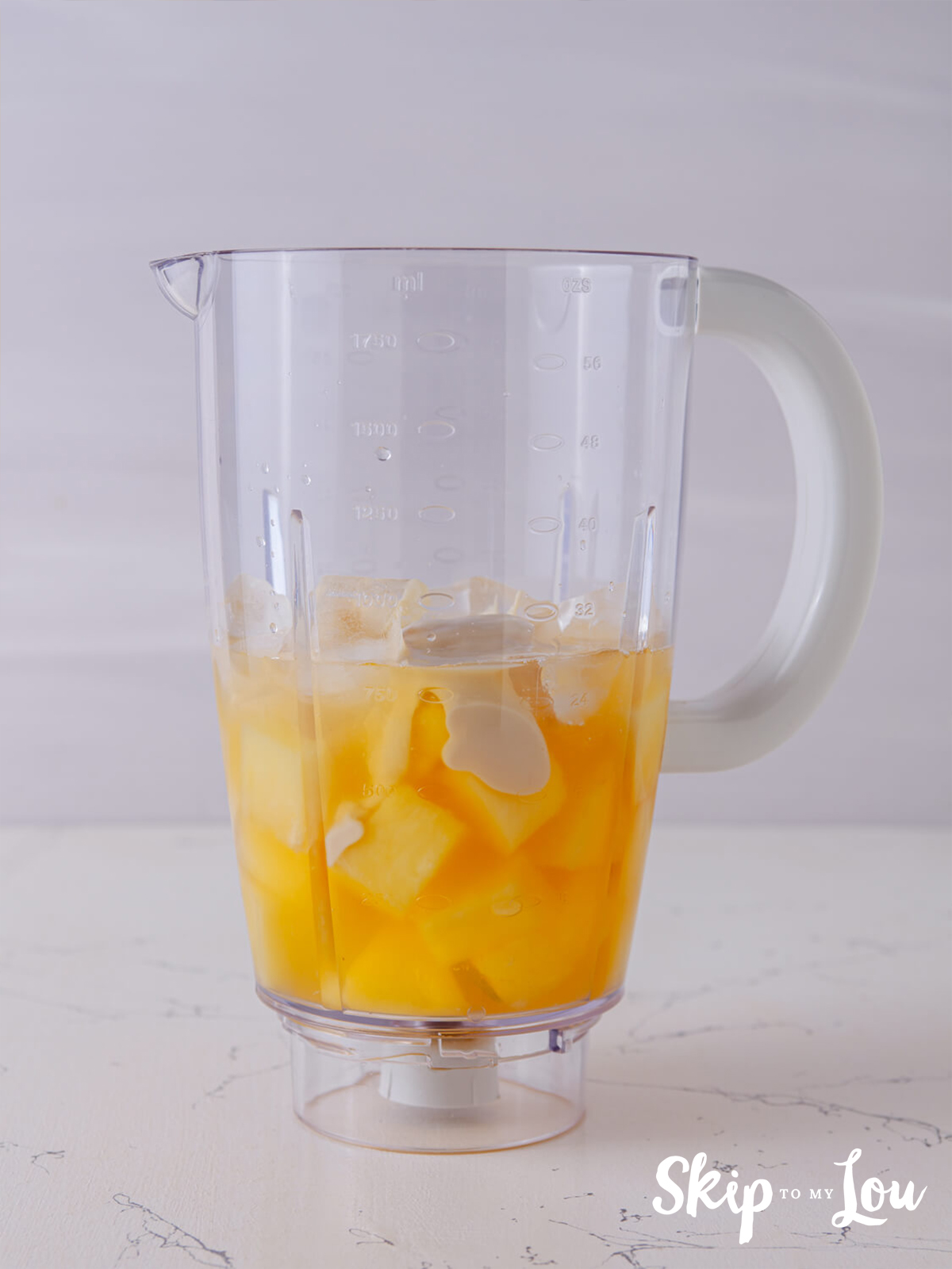 A blender with  frozen pineapple, pineapple juice, coconut cream, rum, and one-quarter cup simple syrup.