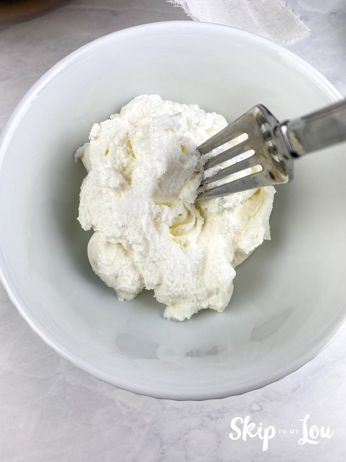A fork being used to combine the Greek yogurt and salt.