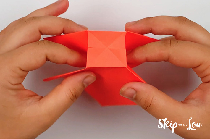 Two hands holding the piece of paper with the square at the top.