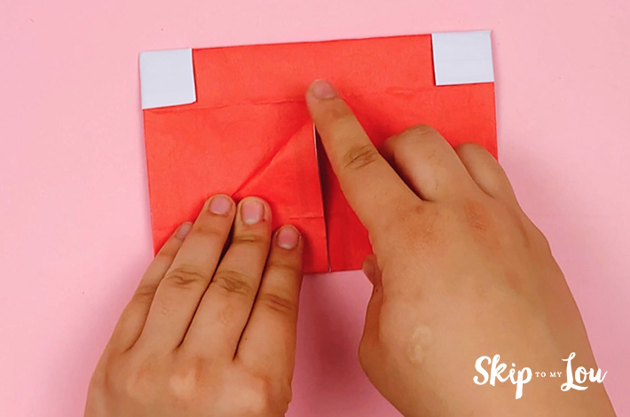 Two hands folding the left-hand side to form a triangle. 