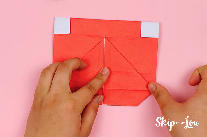 Two hands showing how the flaps will look when folded downwards.