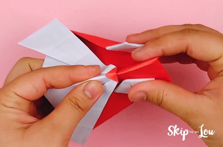 Two hands folding the owl shape in half 
