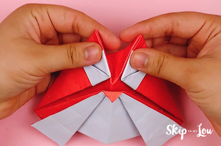 Two hands working the creases to form the head perfectly. 