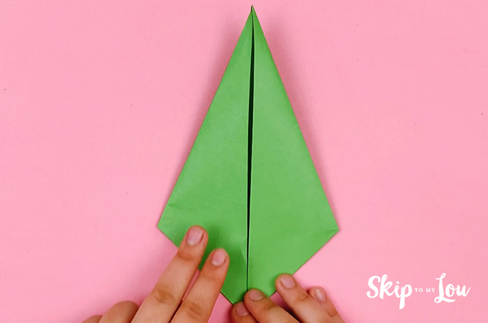 Two hands holding the paper after the folds have been made.