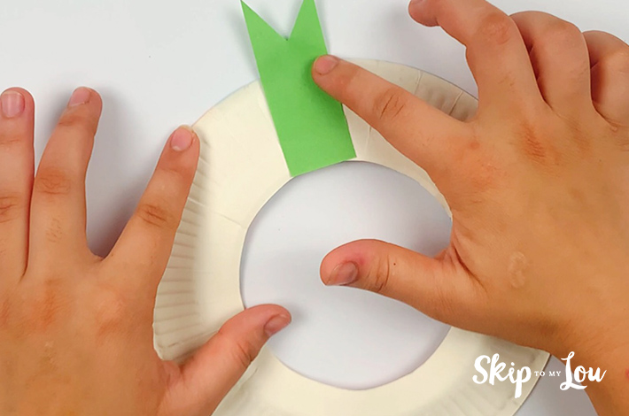 Two hands sticking the first petal to the plate.