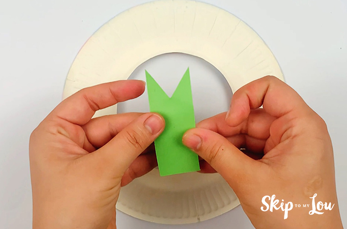 Two hands holding the cut origami wreath petal.