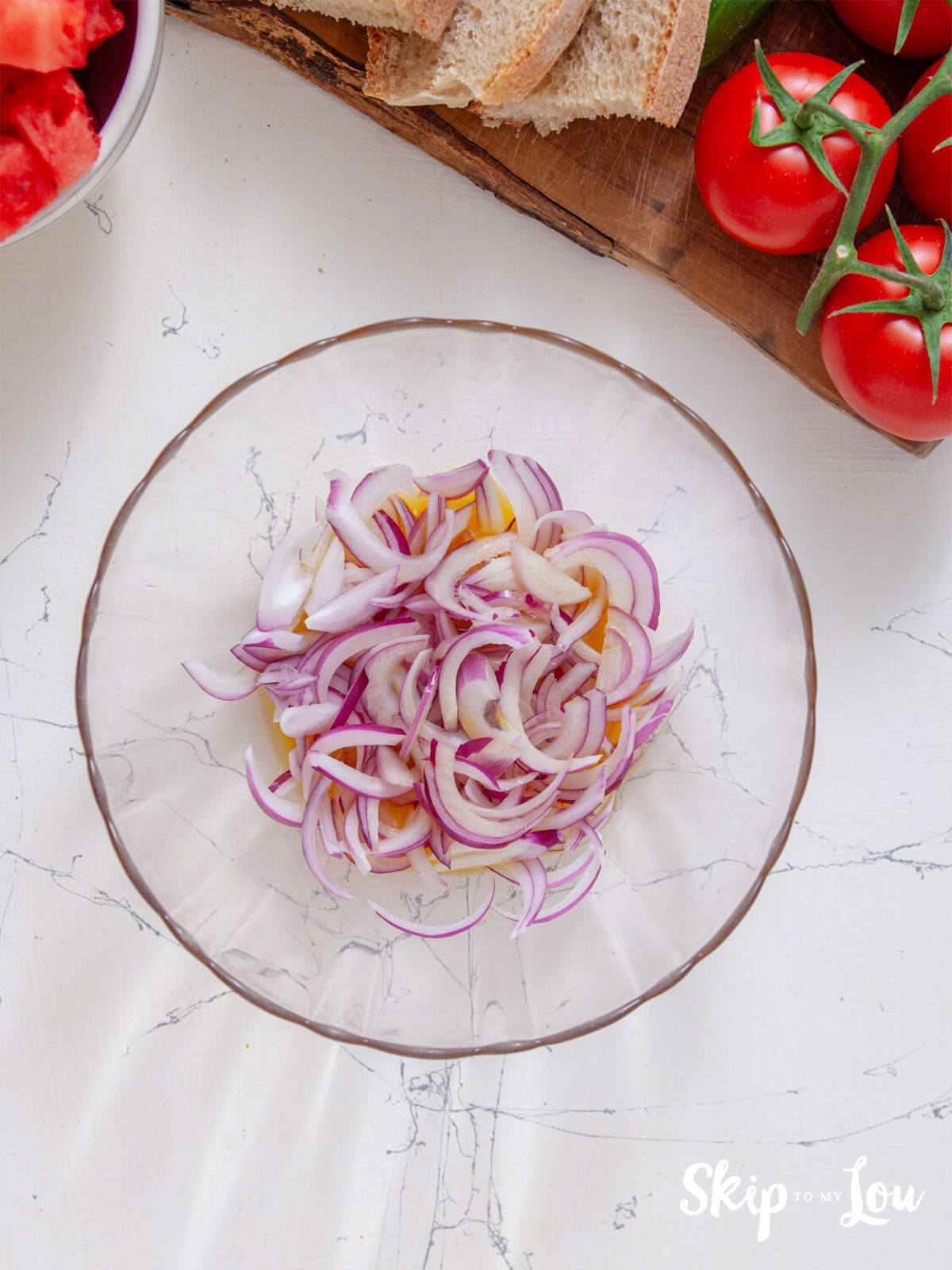 A bowl filled with sliced onion and oranges.