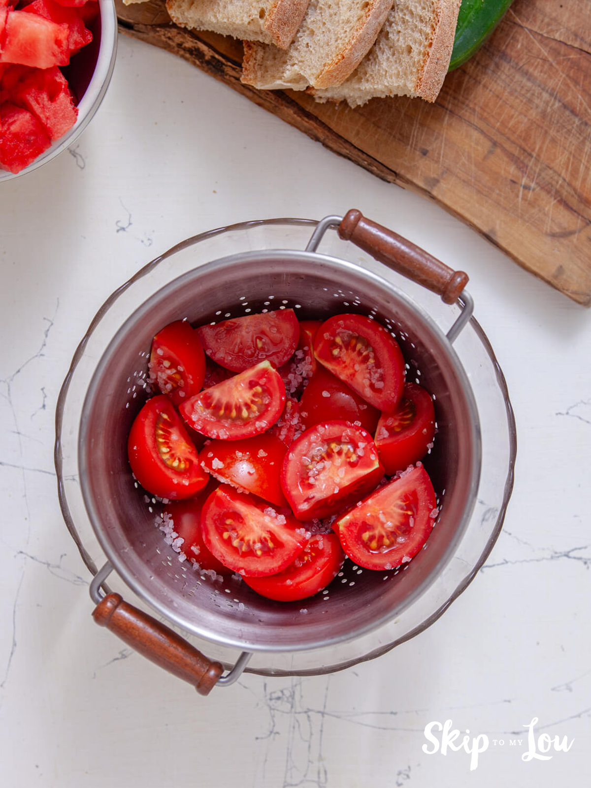 Tomatoes in a colander with added sea salt.