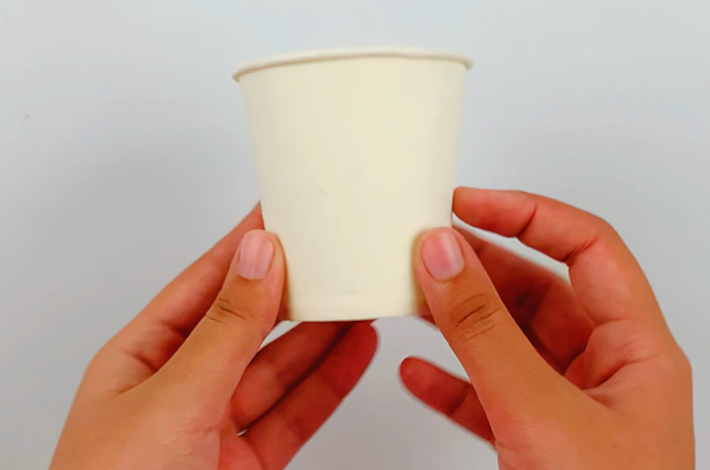Two hands holding a paper cup.