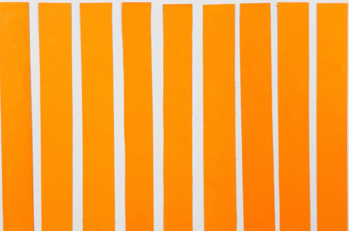 Orange paper cut into nine strips of equal width.