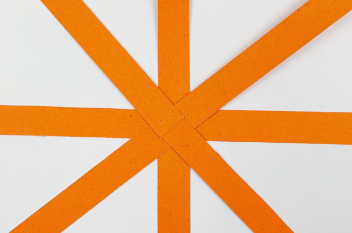 A picture of the remaining strips glues to the orignal two strips from the central point so there is a strip at every 45 degrees, starting from the top.