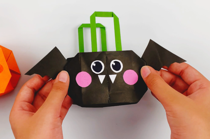 Two hands holding a vampire bat gift bag made using the same folding techniques. 