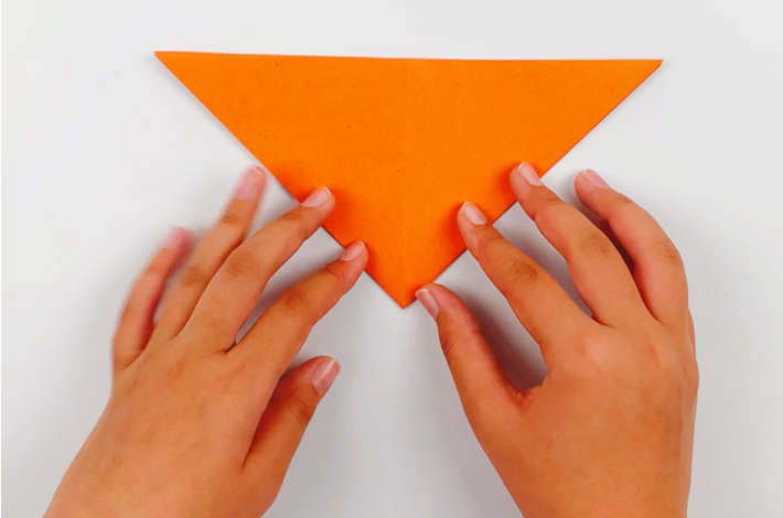 Two hands turning the paper 180 degrees