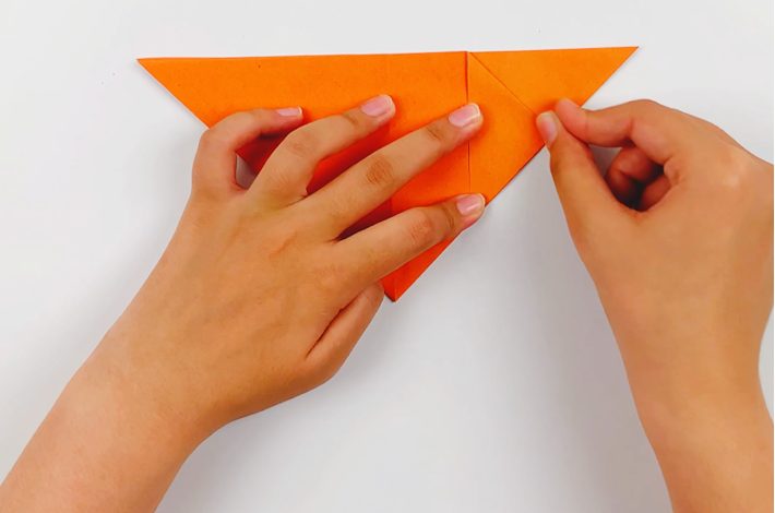 Two hands folding the top falp on the right over.