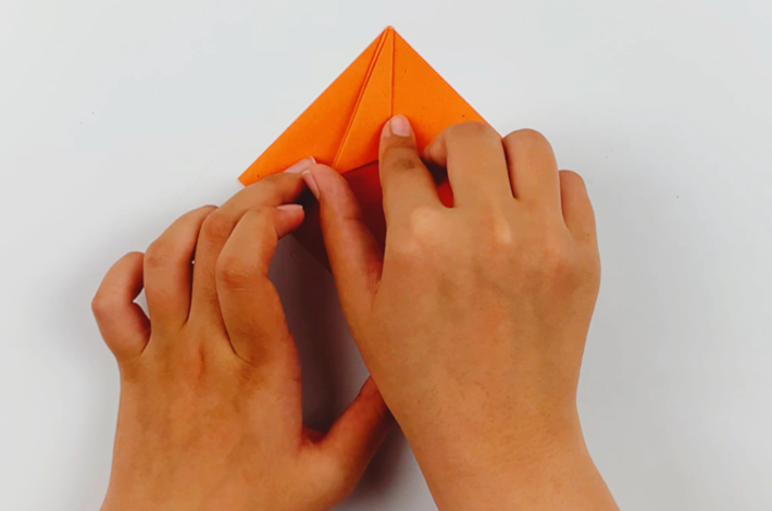 Two hands opening the flaps that were folded.