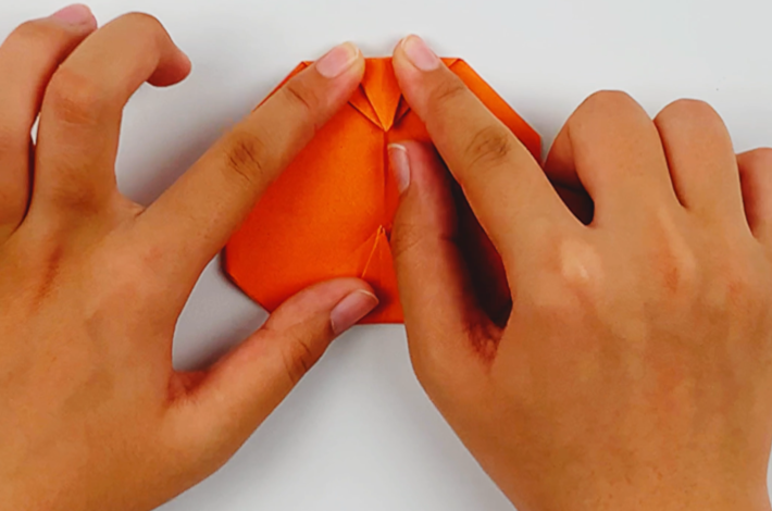 Two hands folding the top section downwards.