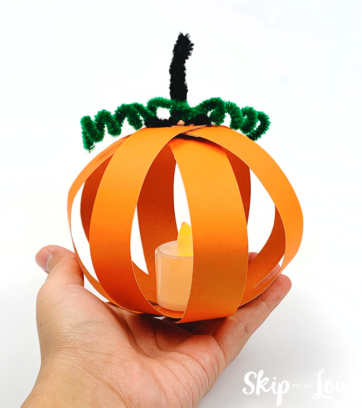 hand holding paper pumpkin