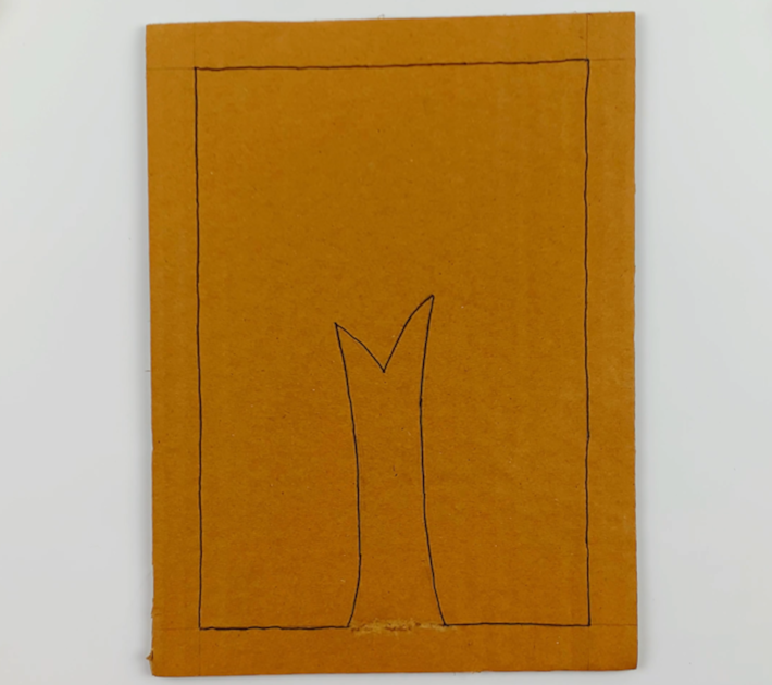 A piece of cardboard with the border lines marked with a black marker, as well as the tree stump form. 
