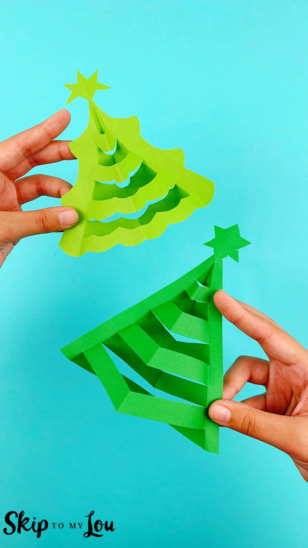 Two hands holding the finished 3D paper trees from two downloadable templates from Skip to My Lou.