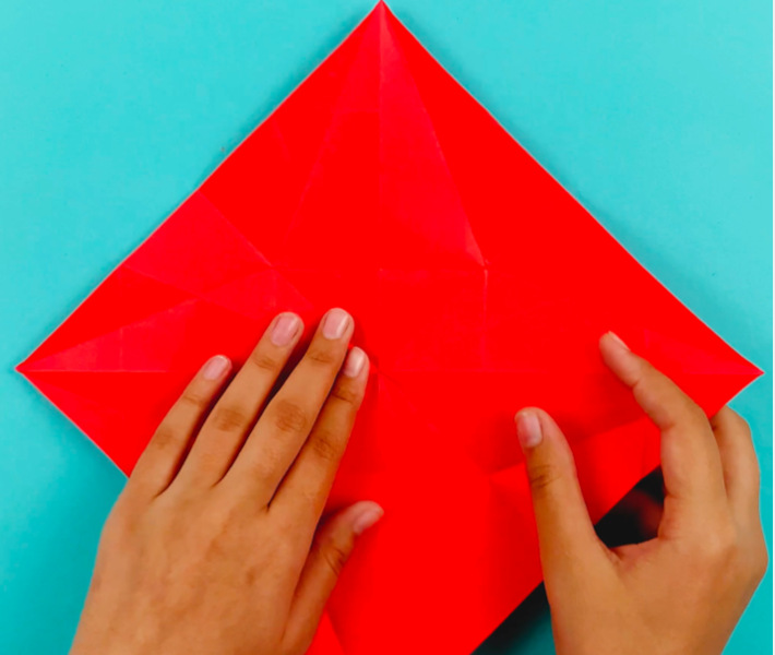 Two hands unfolding the paper.