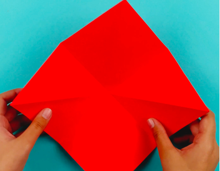 Two hands unfolding the paper.