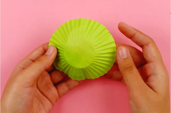 Two hands flipping the cupcake holder over so the green side is showing.