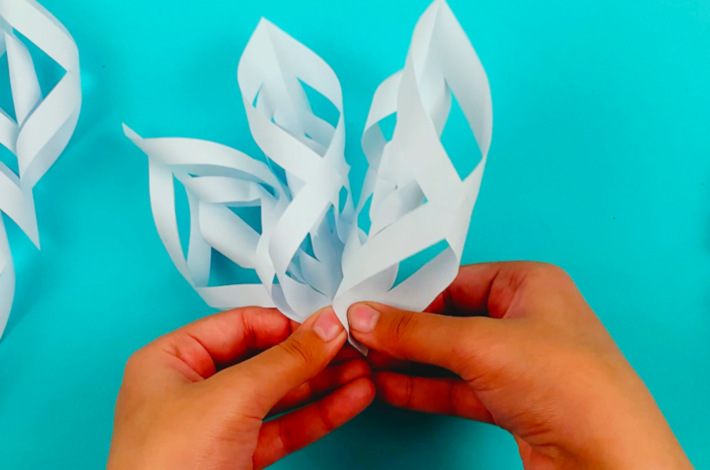 Two hands holding the snowflake sections together.