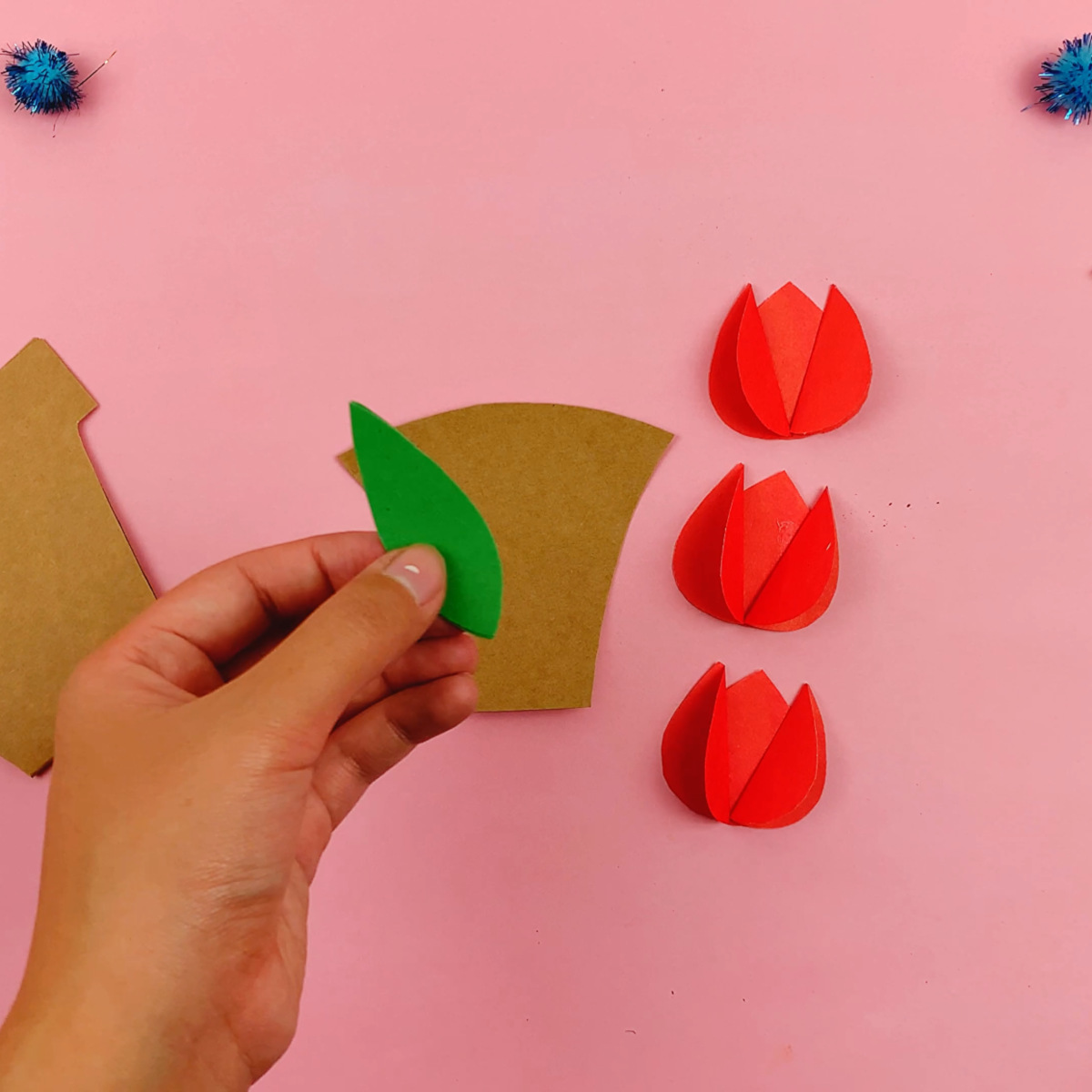 The leaf template is used to cut out four leaf shapes from green paper.