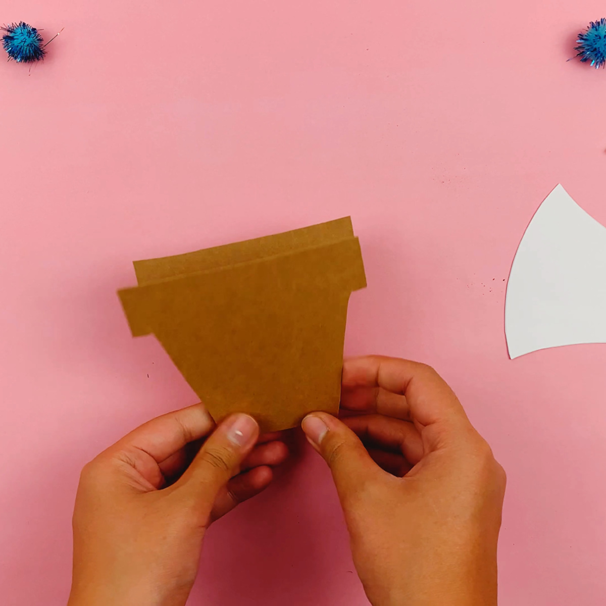 The flower pot template is folded in half once cut out.