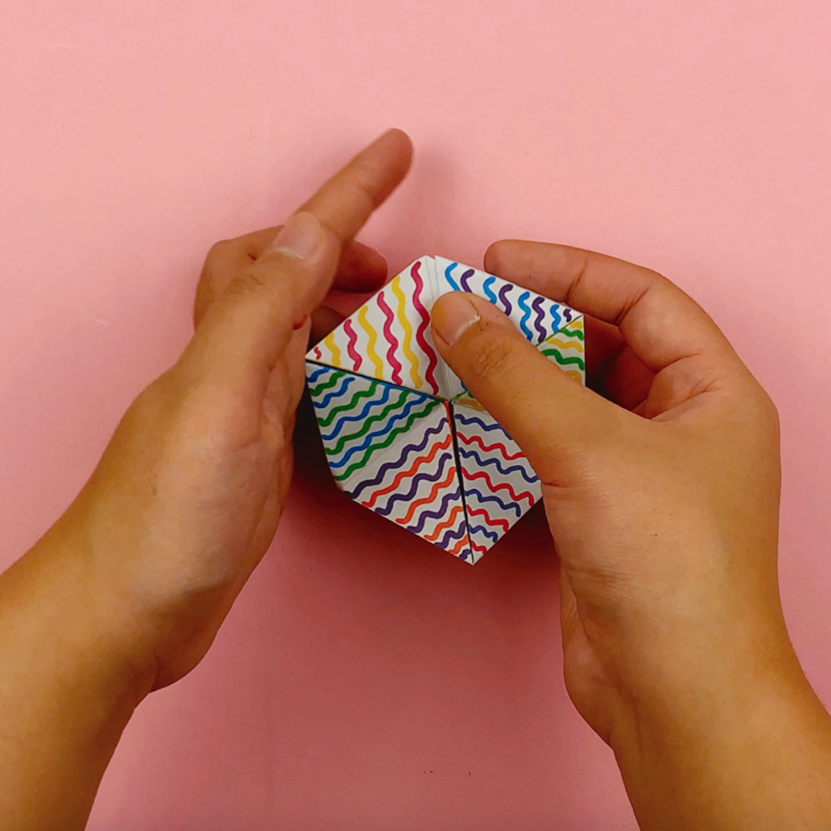 Two hands twisting the flextangle into its final shape.