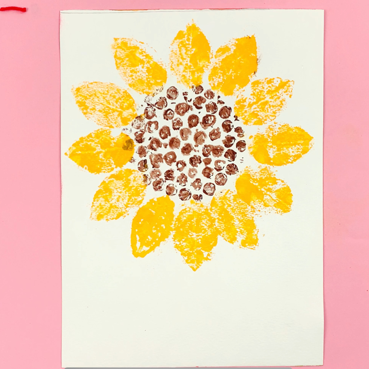 A painted leaf is used to stamp the petals of the sunflower all around the center section.